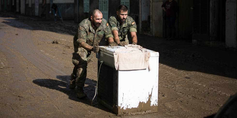 Dos militares ayudan en las tareas de limpieza.