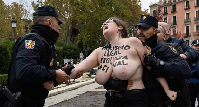 La policía retira a una de las activistas de Femen que han protestado este domingo contra un acto franquista en Madrid.
