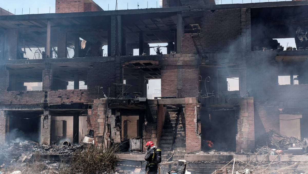 Un bombero trabaja en las labores de extinción del incendio con varias explosiones, originado en un edificio okupado del barrio de Es Viver de Ibiza.