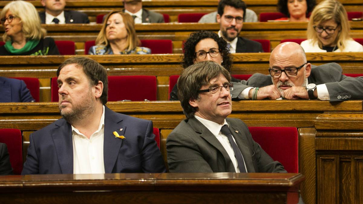 El expresidente de Cataluña, Carles Puigdemont (d) y Oriol Junqueras durante el pleno en el que se debatió la respuesta a la aplicación del artículo 155, en 2017.