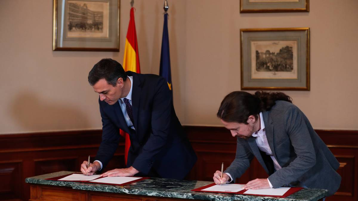 El presidente del Gobierno, Pedro Sánchez, y el secretario general de Unidas Podemos, Pablo Iglesias, firman su acuerdo este martes.