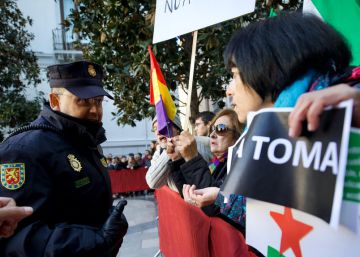 Un policía habla con manifestantes en contra de los actos de la Toma de Granada.