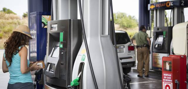 Una mujer reposta gasolina Una mujer reposta gasolina