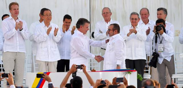 El presidente de Colombia, Juan Manuel Santos, le da la mano a Rodrigo Londoño, alias Timochenko, líder de las FARC, tras la firma del acuerdo final. El presidente de Colombia, Juan Manuel Santos, le da la mano a Rodrigo Londoño, alias Timochenko, líder de las FARC, tras la firma del acuerdo final.