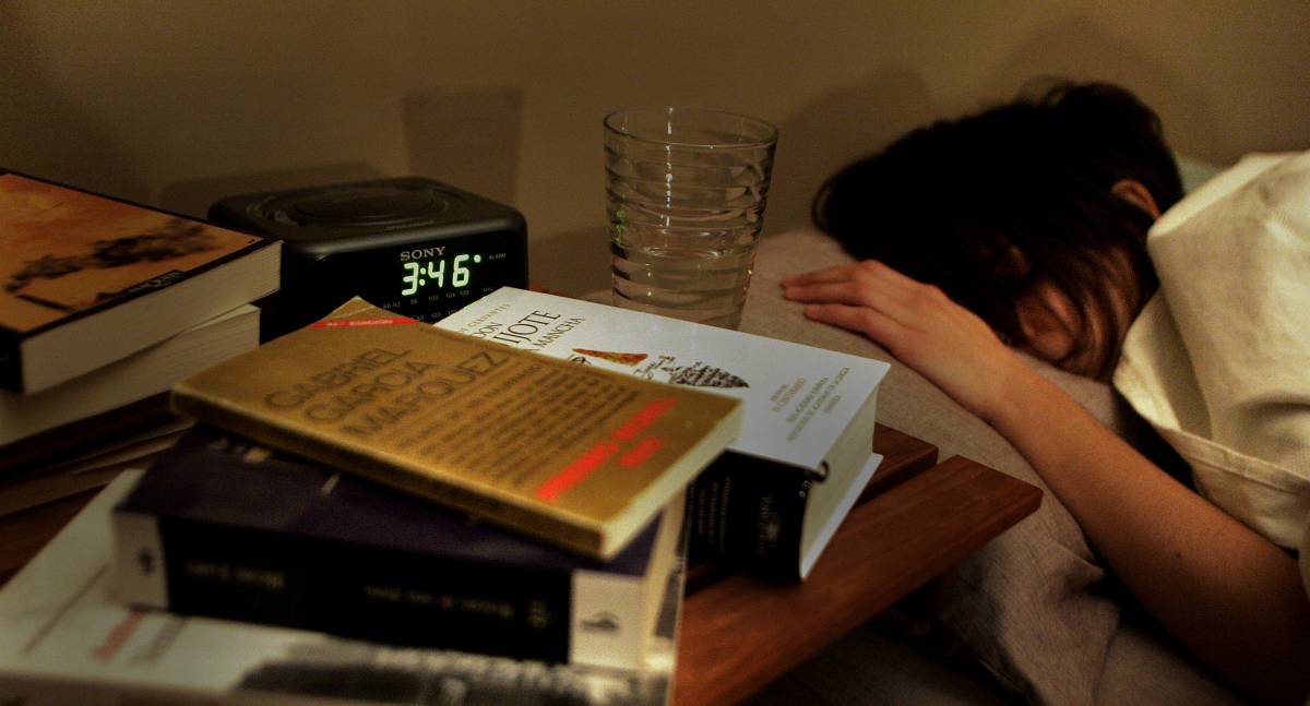 Una mujer duerme junto al despertador.