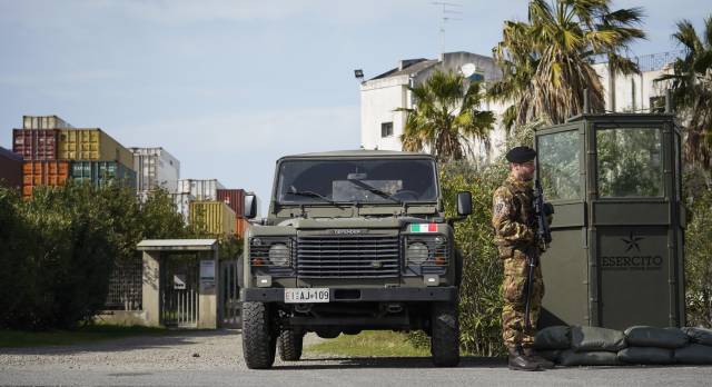 Un militar del ejército italiano protege la entrada de una de las empresas de la zona, cerca del puerto de Gioia Tauro, en Calabria (Italia).