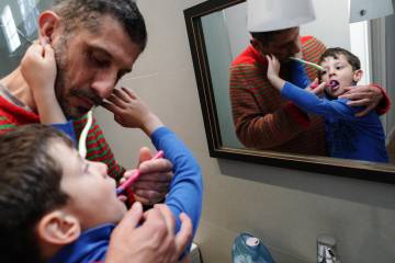 Fernando Nuño Santana cepilla los dientes a su hijo Martín.