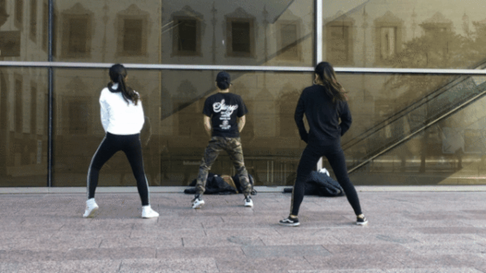 La Keesha, l'Aaron i la Chenoa utilitzen la paret de vidre del CCCB com a mirall per practicar les coreografies que aprenen a YouTube.