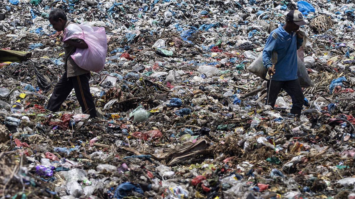 Dos personas rebuscan en la basura en el vertedero de la ciudad de Lhokseumawe (Indonesia).