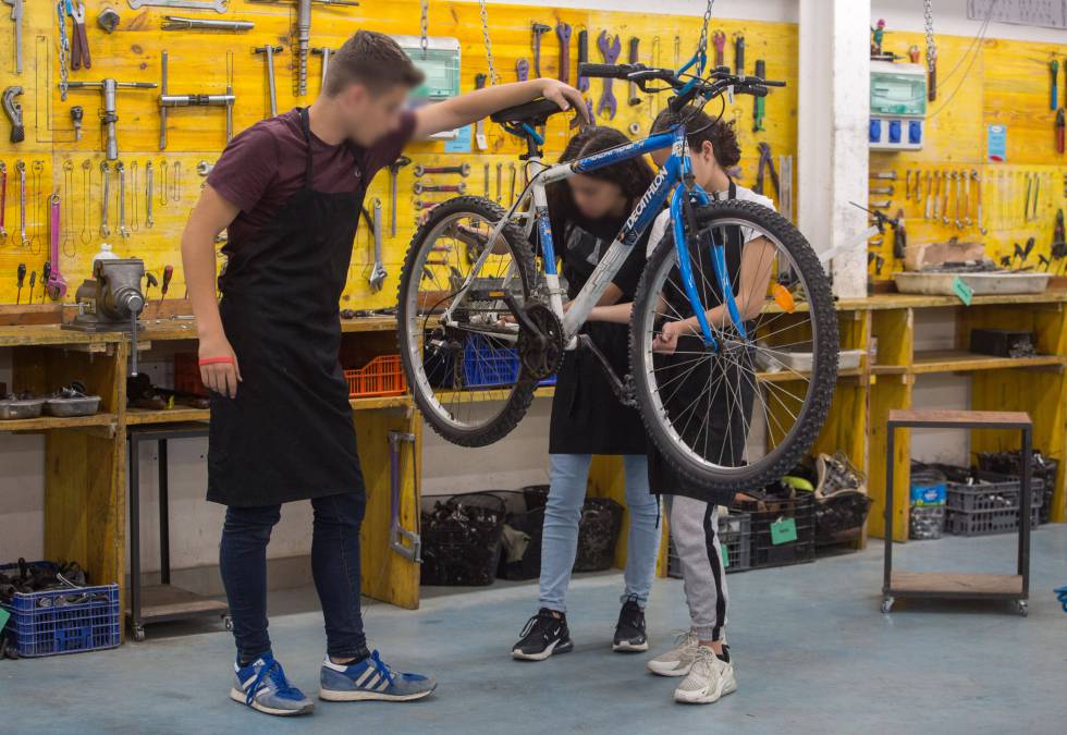 José, Dikra y Chaimaa, tres alumnos del instituto público Verdaguer de Barcelona, durante una clase de reparación de bicicletas.