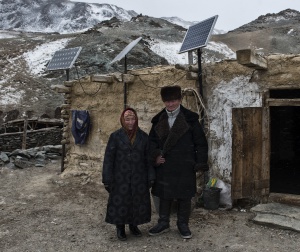Incluso en las zonas más montañosas del extremo occidental del país, las placas solares han cambiado el ritmo de vida de los nómadas de la etnia kazaja. En la fotografía, Tolhinbai Kenje (izda.) y Uranbai Samat (dcha.) posan bajo las tres placas solares de su casa de invierno.