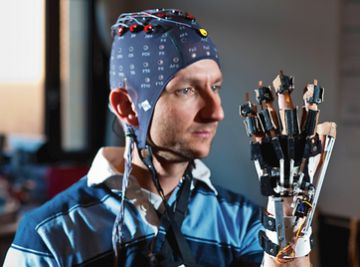 Un colaborador del profesor Millán lleva puesta la capucha de electrodos y practica para mover una mano con la mente.