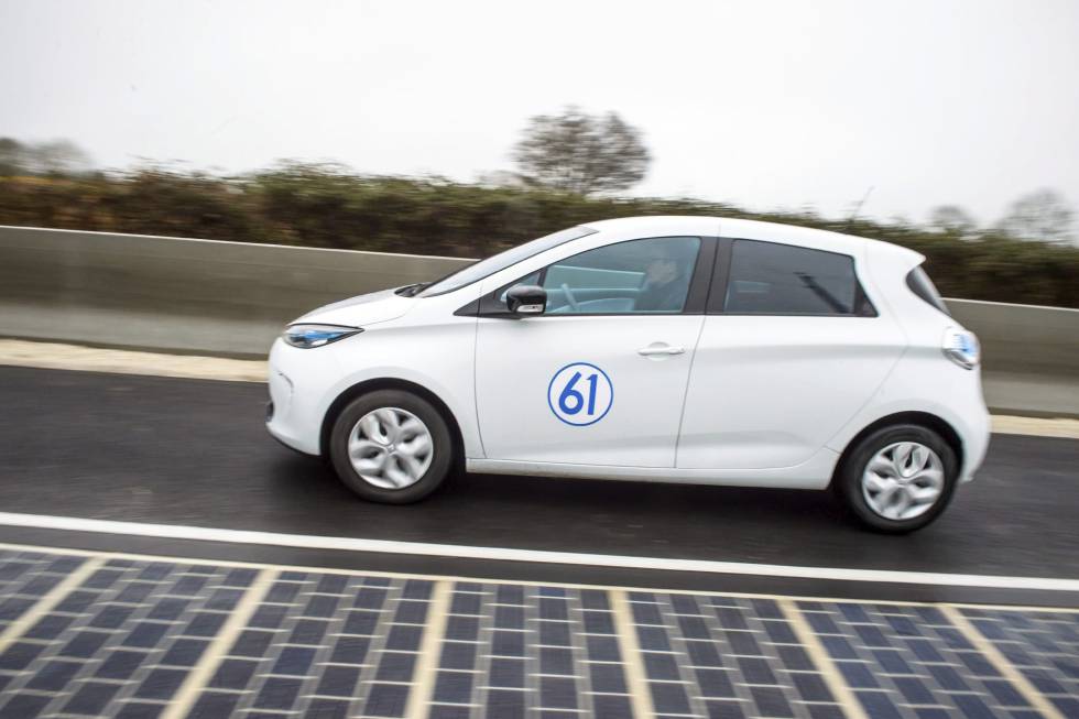 Un coche eléctrico conduce en la primera carretera equipada con paneles solares, en Tourouvre au Perche, Francia. 