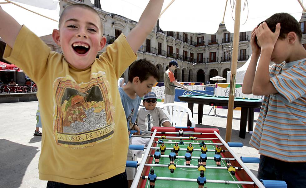 Varios niños juegan al futbolín en la plaza Nueva de Vitoria, durante la campaña