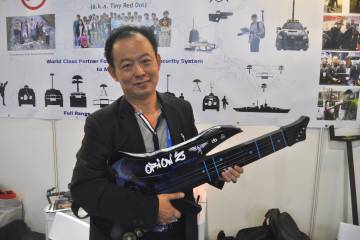 Sam Ong, director de la consultora singapurense TRD, posa en la Feria de Aviación de Singapur con un objeto con forma de guitarra que contiene un inhibidor de frecuencia, una técnica llamada