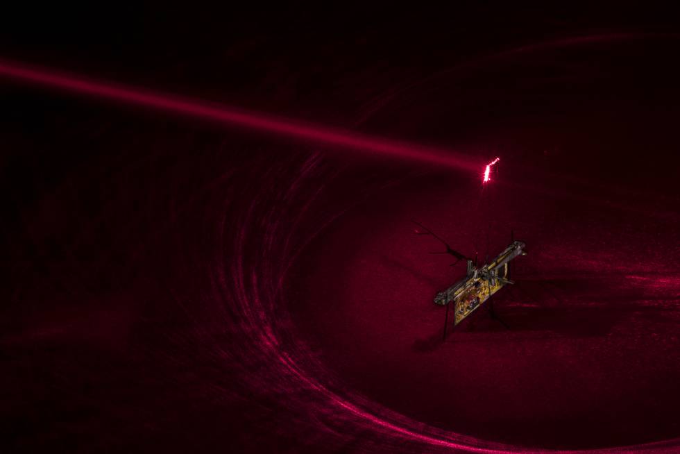 Para que RoboFly funcione los ingenieros apuntaron un rayo láser invisible (aquí se muestra en rojo) a una célula fotovoltaica adjuntada encima del robot que convierte la luz láser en electricidad.
