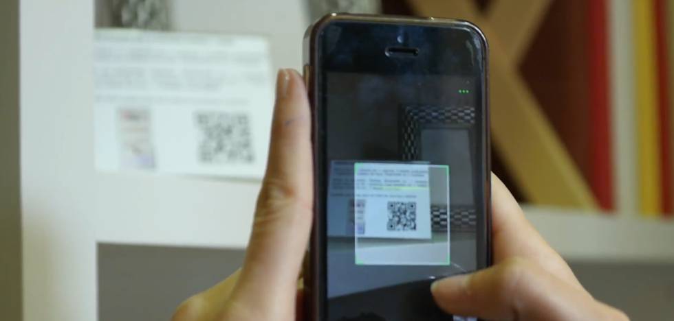 Una cliente consulta mediante un código QR en la tienda física sin dependientes deTudecora.com en Guadalajara.