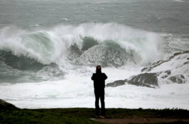 Una ola rompe próxima a la Torre de Hércules, en A Coruña