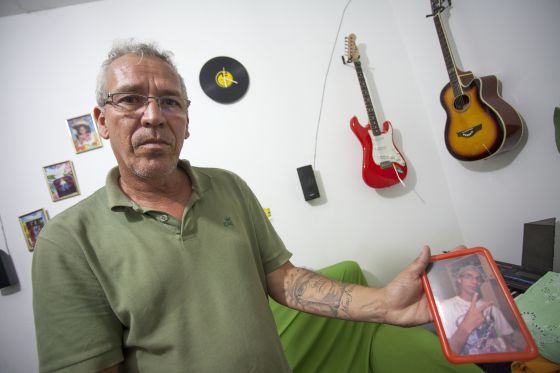 Daniel Eustáquio mostra a tatuagem e uma foto de seu filho César, morto por PMs.