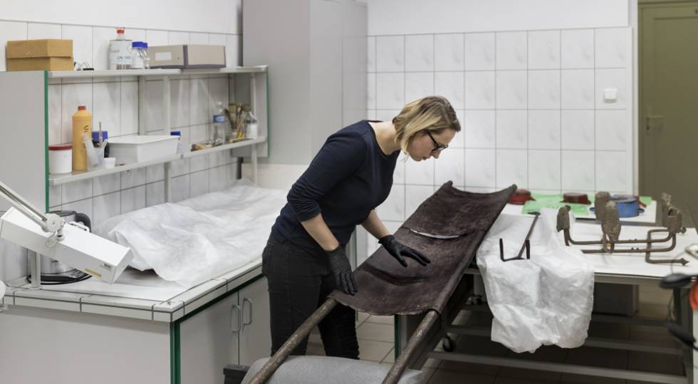 Marta Swieton, membro da equipe de restauração, analisa uma maca utilizada no crematório.