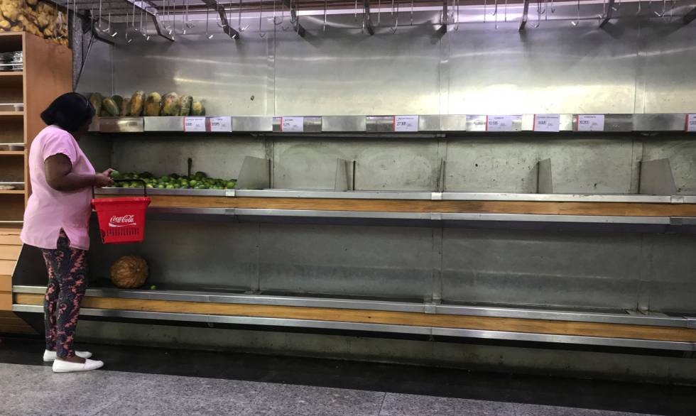 Mulher seleciona limões em um supermercado em Caracas.