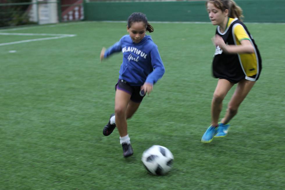 Lara, à esquerda, disputa a bola com outra menina.