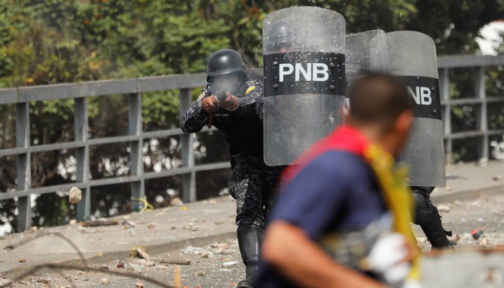 Policial atira bala de borracha contra manifestante em Caracas. 
