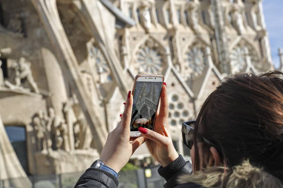 Una dona fotografia la Sagrada FamÃlia.
