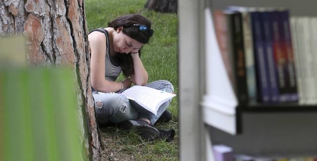 Una mujer lee en El Retiro de Madrid durante la Feria del Libro de 2017. 
