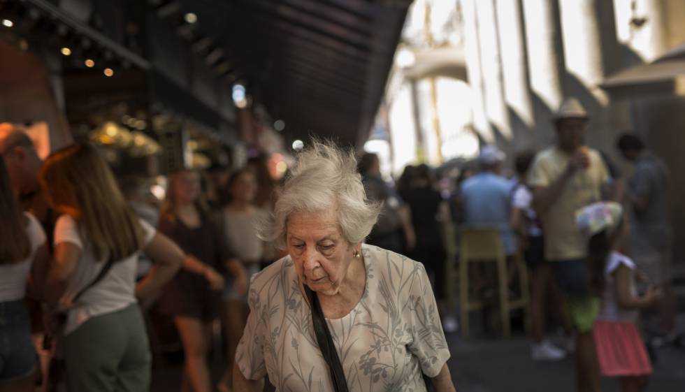 Una anciana pasea por el Mercado de la Boquería de Barcelona