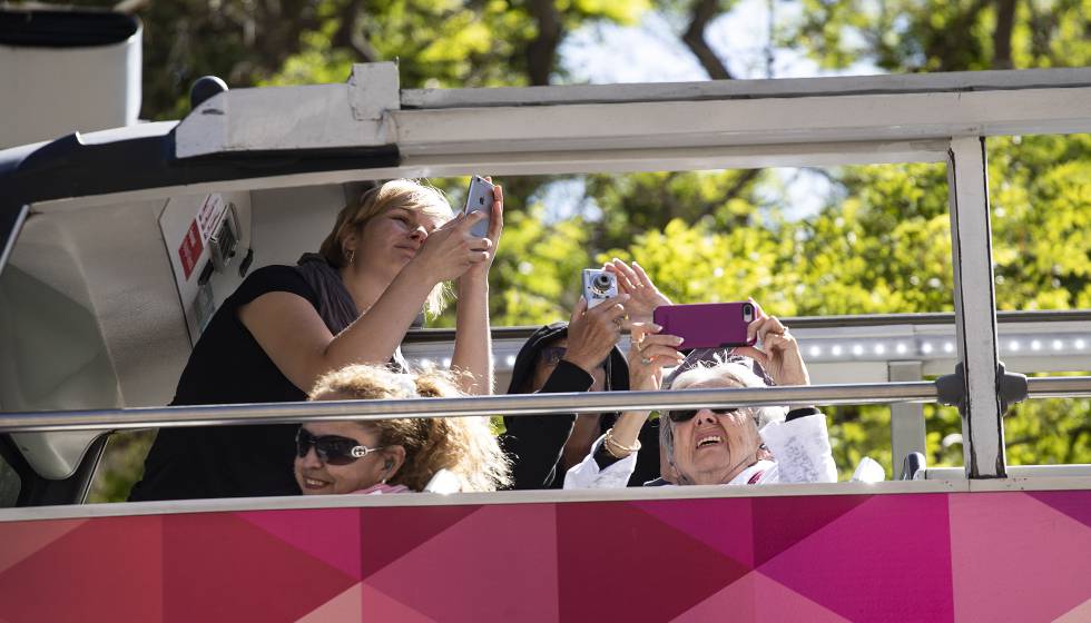 Turistas haciendo fotos en la Sagrada Familia desde un autobús.