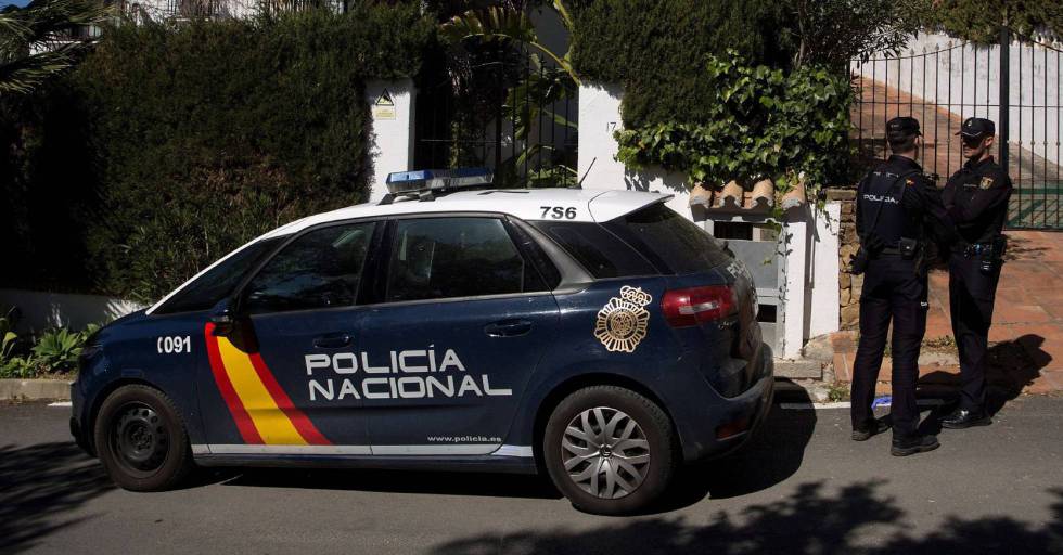 Dos policías nacionales junto a un coche patrulla, en una imagen de archivo.