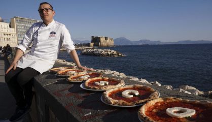 El chef Gino Sorbillo con sus pizzas con las letras de la Unesco.