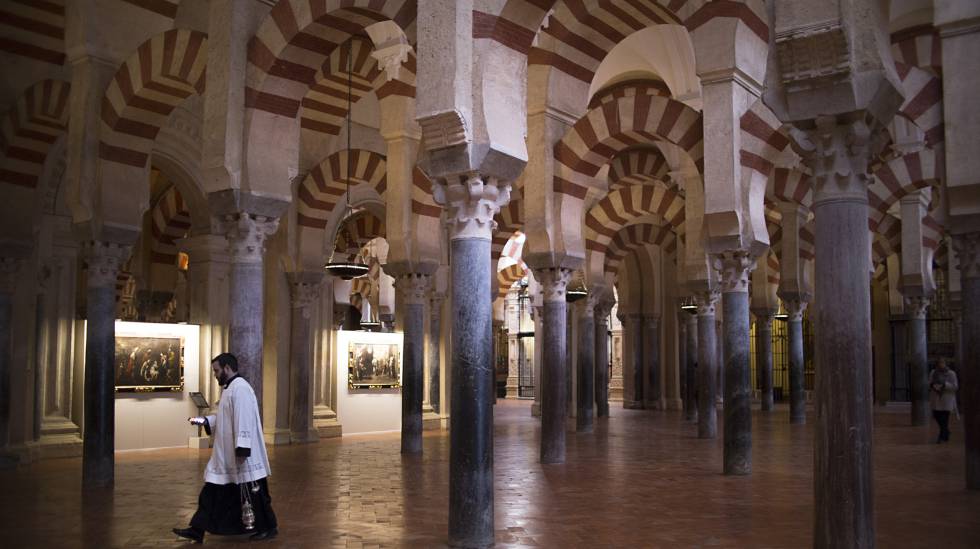 Un monaguillo bajo los arcos bicolor de la Mezquita de Córdoba.