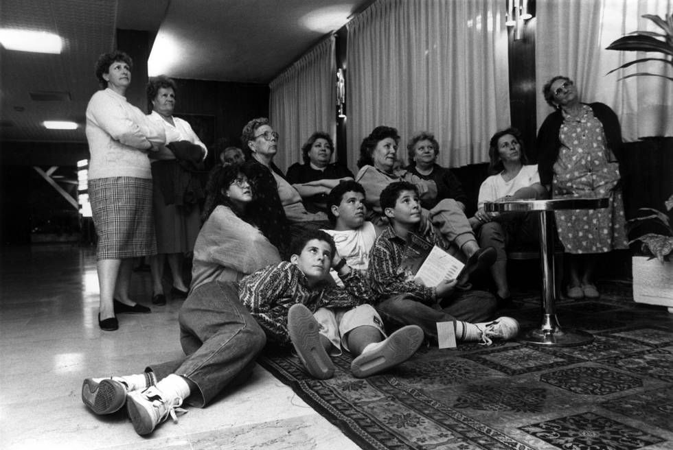 Unas vecinas, acompañadas de sus hijos, contemplan en la telenovela 'Cristal' en la televisión del hotel Colón, tras ser desalojados de sus viviendas al formarse en su edificio una bolsa de gas debido a un escape de Gas Madrid.