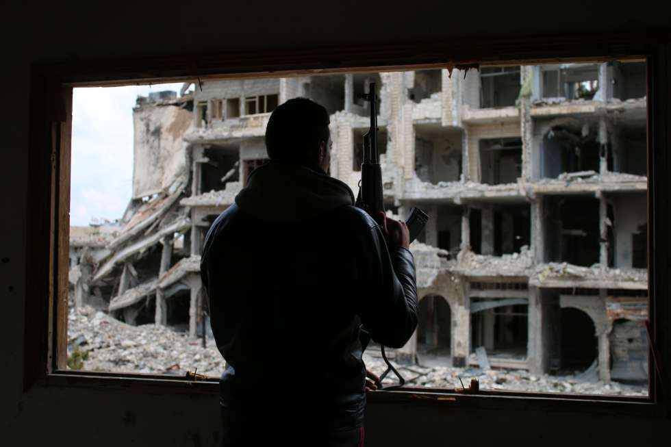 Un rebelde sirio observa los daños de la guerra en un barrio de Daraa, al sur del país.