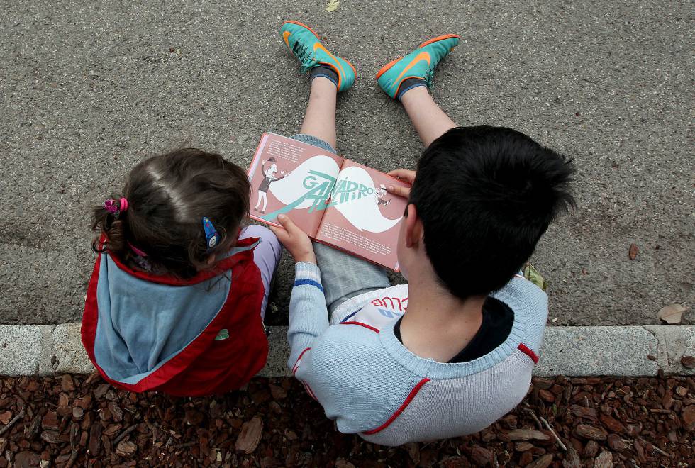 Niños leyendo en la Feria del Libro de Madrid, en el parque del Retiro.