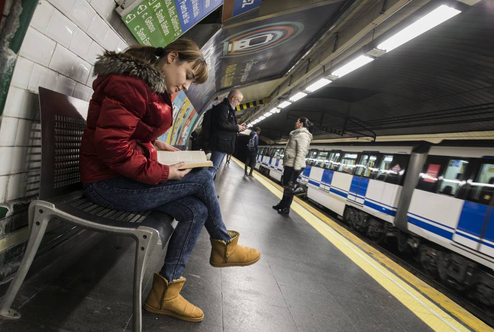 Una joven lee mientras espera el metro, ayer en la estación de Alonso Martínez, en Madrid.