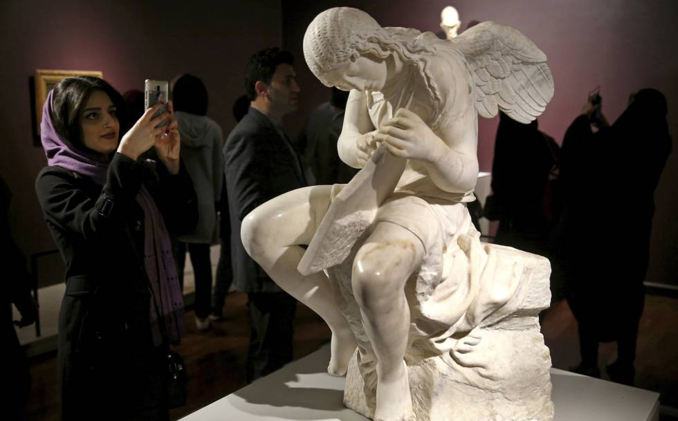 Una mujer junto a la escultura 'Funerary Genius' en la exposición 'El Louvre en Teherán', inaugurada el 5 de marzó en Teherán. 
