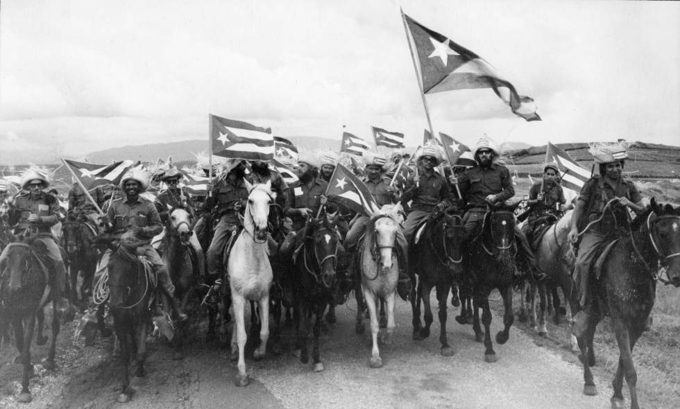 El revolucionario Camilo Cienfuegos porta una gran bandera de Cuba en una marcha de campesinos en 1959. 