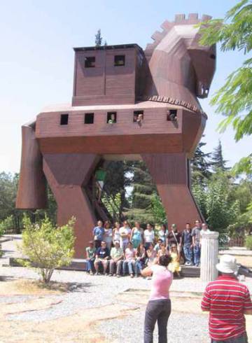 Un grupo de turistas posa ante una reproducción del caballo de Troya.