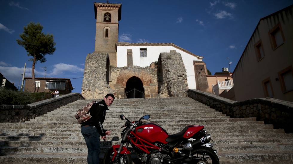 Un hombre aparca una moto frente a la iglesia de Maqueda.