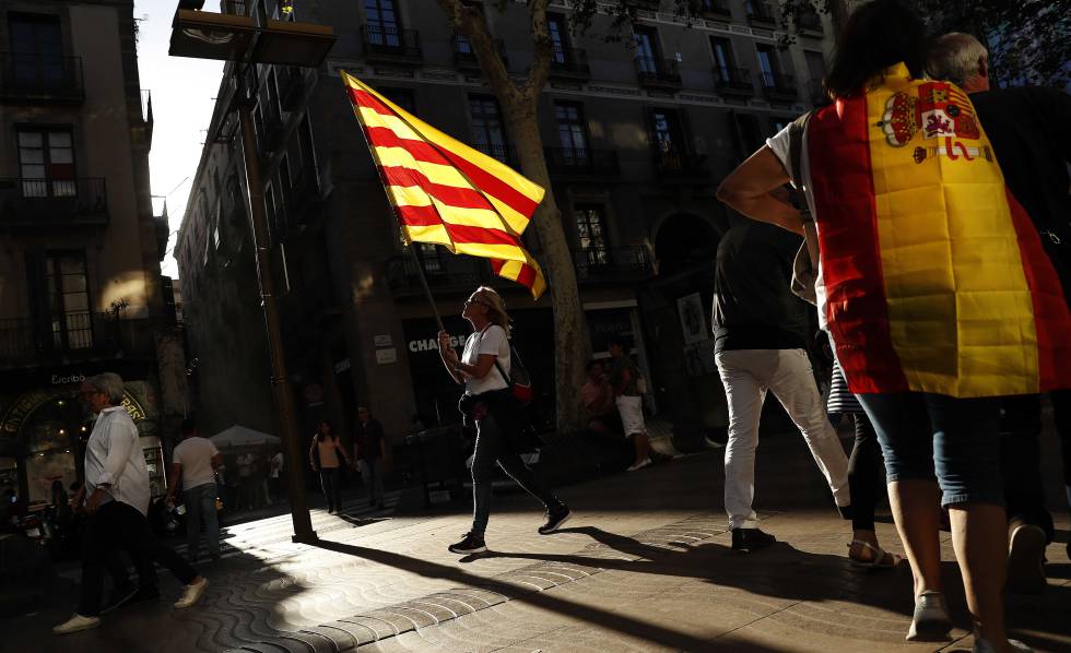 Dos mujeres con una bandera de EspaÃ±a y otra de CataluÃ±a.