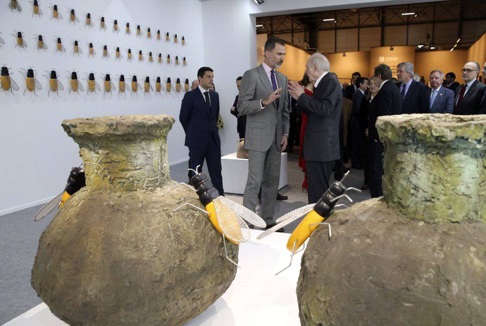 Eduardo Arroyo conversa con el rey Felipe VI, el pasado febrero en el estand de EL PAÃS en Arco, diseÃ±ado por el artista.