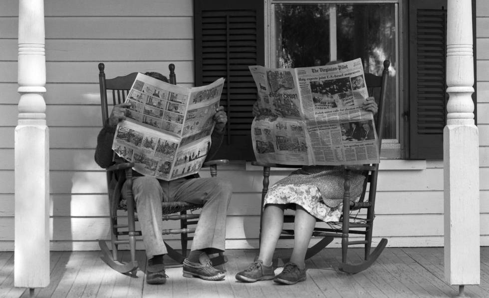 Una pareja lee el periÃ³dico en unas mecedoras.