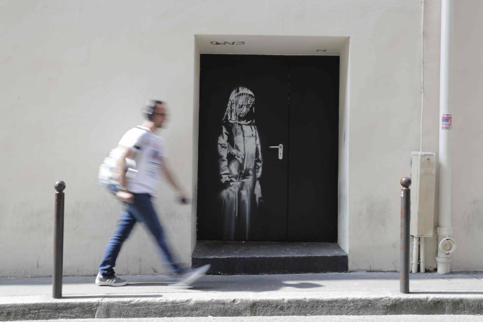 Um homem passa, em julho, diante da saÃ­da de emergÃªncia do Bataclan com a obra de Banksy.
