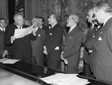 Representantes de la Fundación Juan March, la Biblioteca Nacional, el Gobierno y Ramón Menéndez Pidal (cuarto por la derecha), en el acto de entrega del códice del Cantar de Mío Cid, el 20 de diciembre de 1960. Abajo, la portada y los primeros versos del manuscrito.