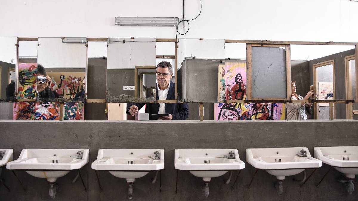 Un aspecto de la muestra 'Colinas de sal', del artista David Colinas (en el centro), en los baños de los facultativos de la mina Pozo Julia, el sábado en Fabero (León).