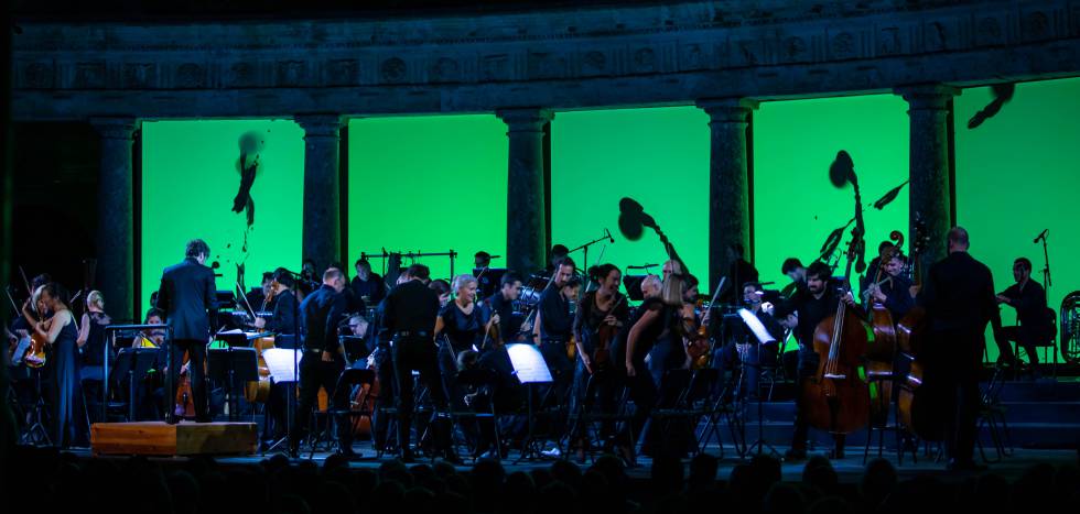 The members of the Mahler Chamber Orchestra leave the stage of the Palace of Carlos V for the rain.