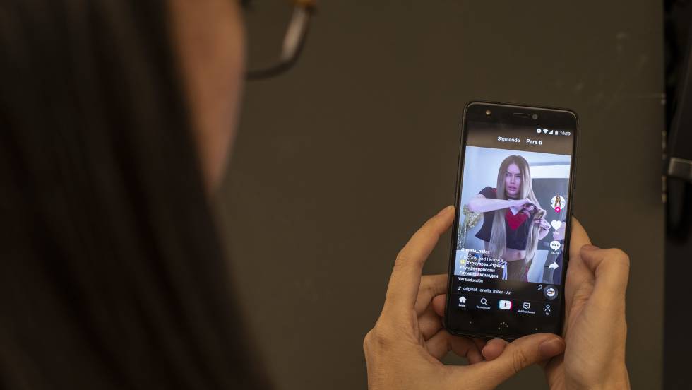 Uma mulher assiste a um vídeo no TikTok. No vídeo, o trailer do app.